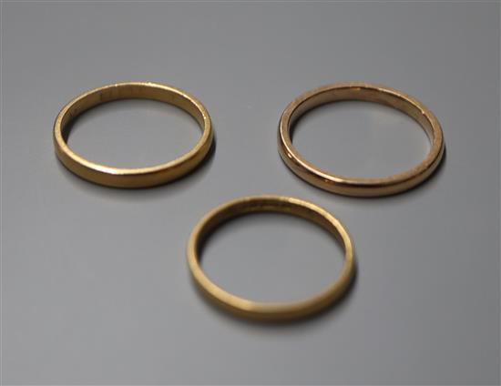 A 22ct gold wedding ring, an 18ct gold wedding ring and a yellow metal wedding ring.